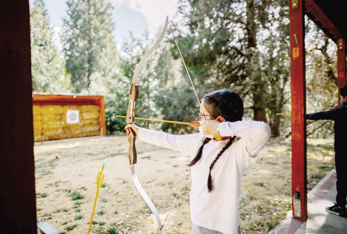 Scouts practicing archery at den meeting
